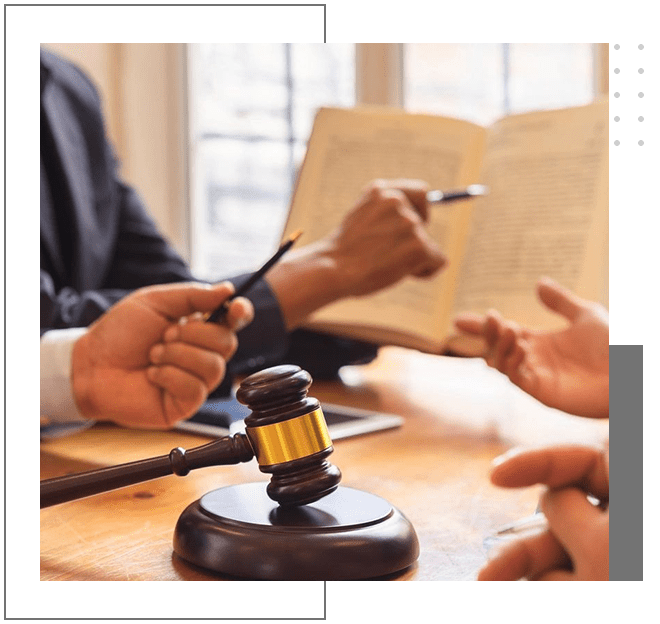 A group of people sitting around a table with papers and gavel.